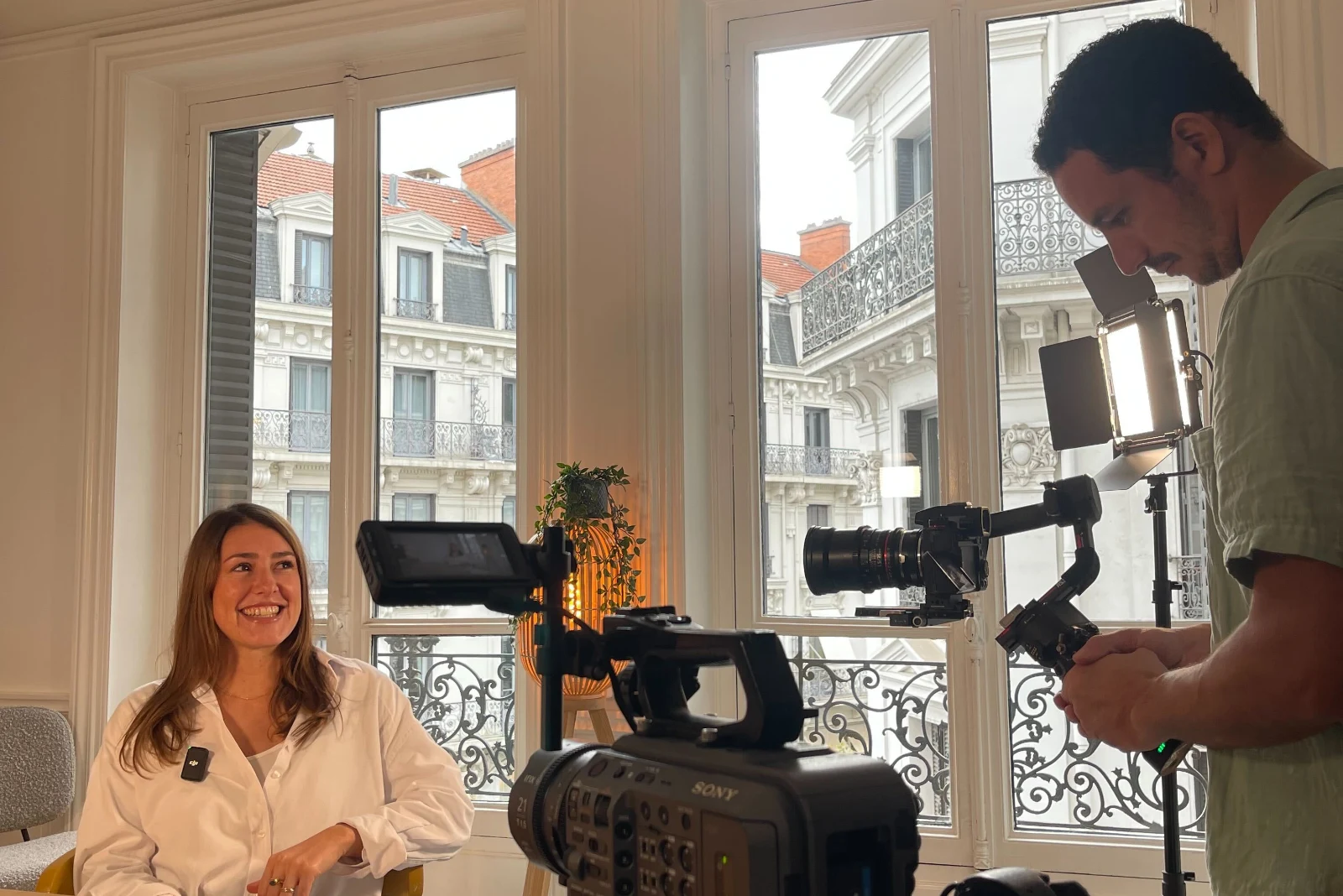 An interview shoot: camera on sticks, a gimbal rig, and the windows of a Lyon flat